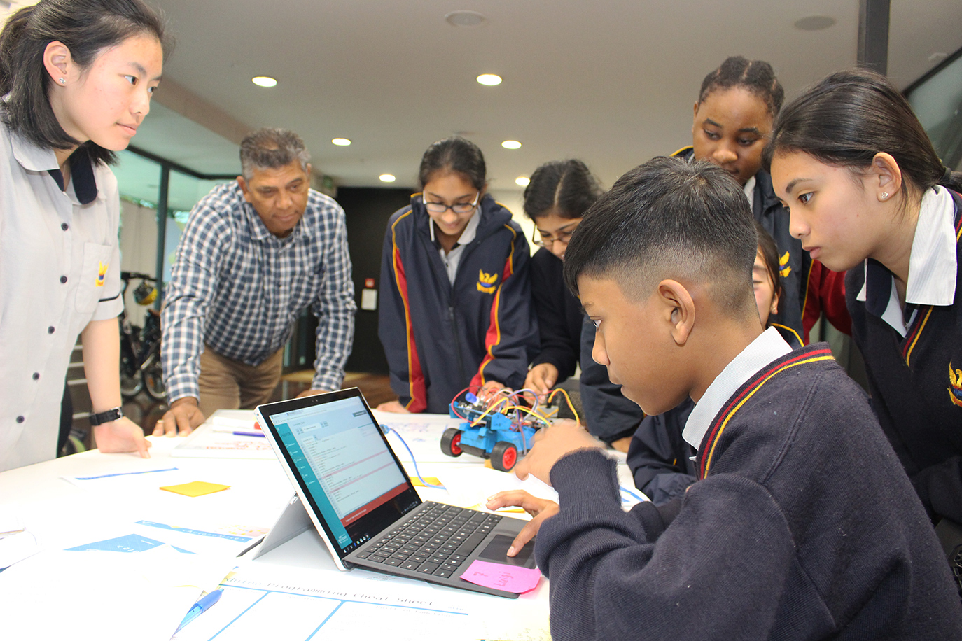 Students and teacher code a model semi-autonomous car.
