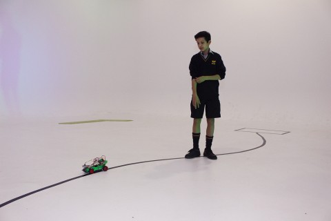 A student follow his car's progress during a test run.