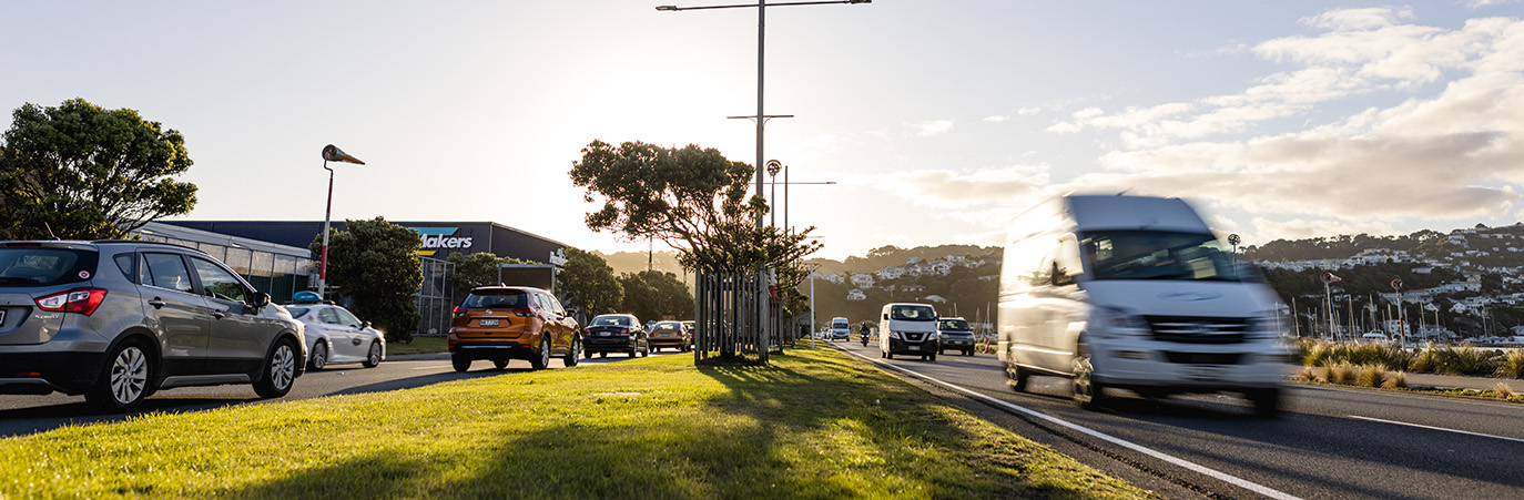 Cars and vans driving on a street.