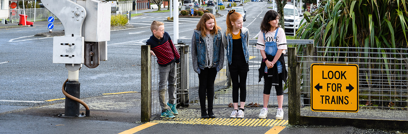 Children look carefully at rail crossing.